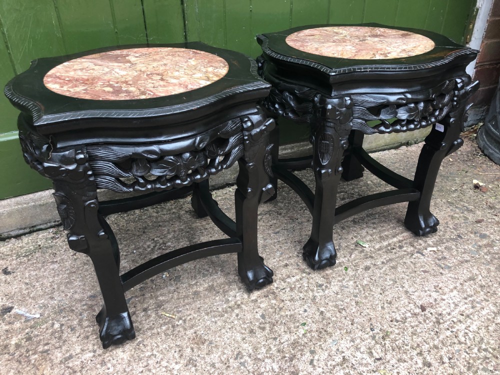 Pair of ebonised wooden side tables featuring pierced floral carvings and circular pink marble inset tops. View III