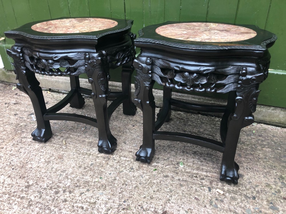 Pair of ebonised wooden side tables featuring pierced floral carvings and circular pink marble inset tops. View V