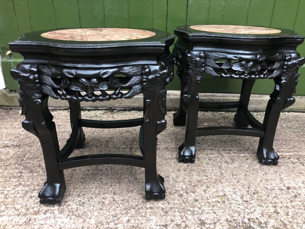 Pair of ebonised wooden side tables featuring pierced floral carvings and circular pink marble inset tops. View VIII