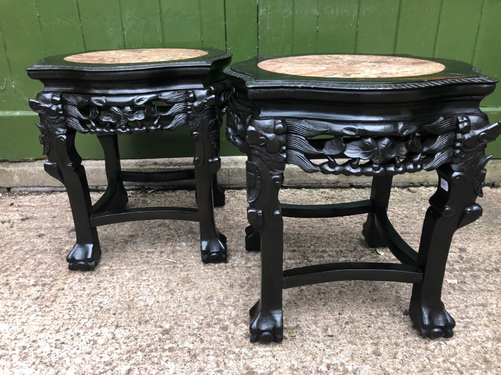 Pair of ebonised wooden side tables featuring pierced floral carvings and circular pink marble inset tops. View IX