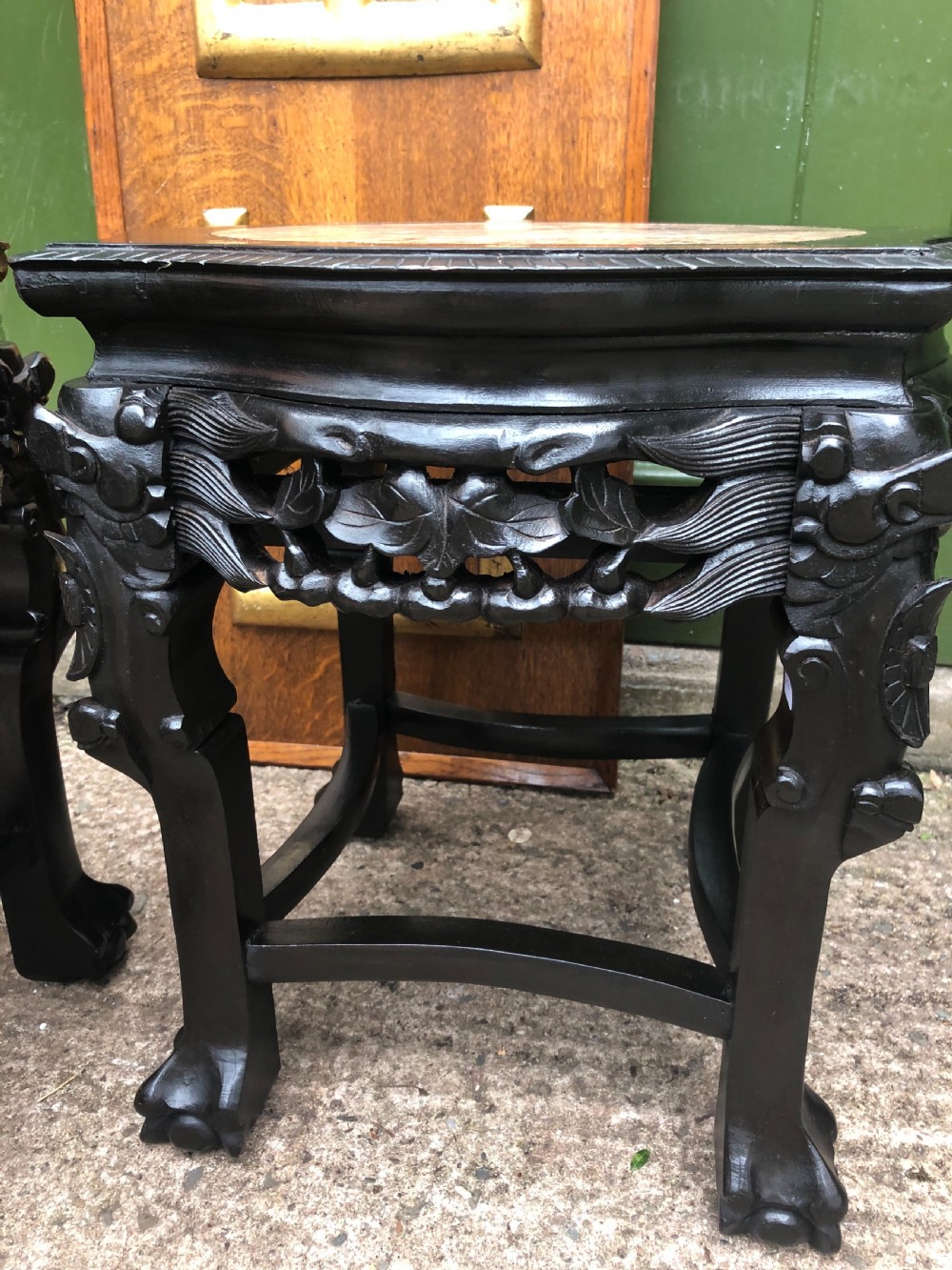 Pair of ebonised wooden side tables featuring pierced floral carvings and circular pink marble inset tops. View XII