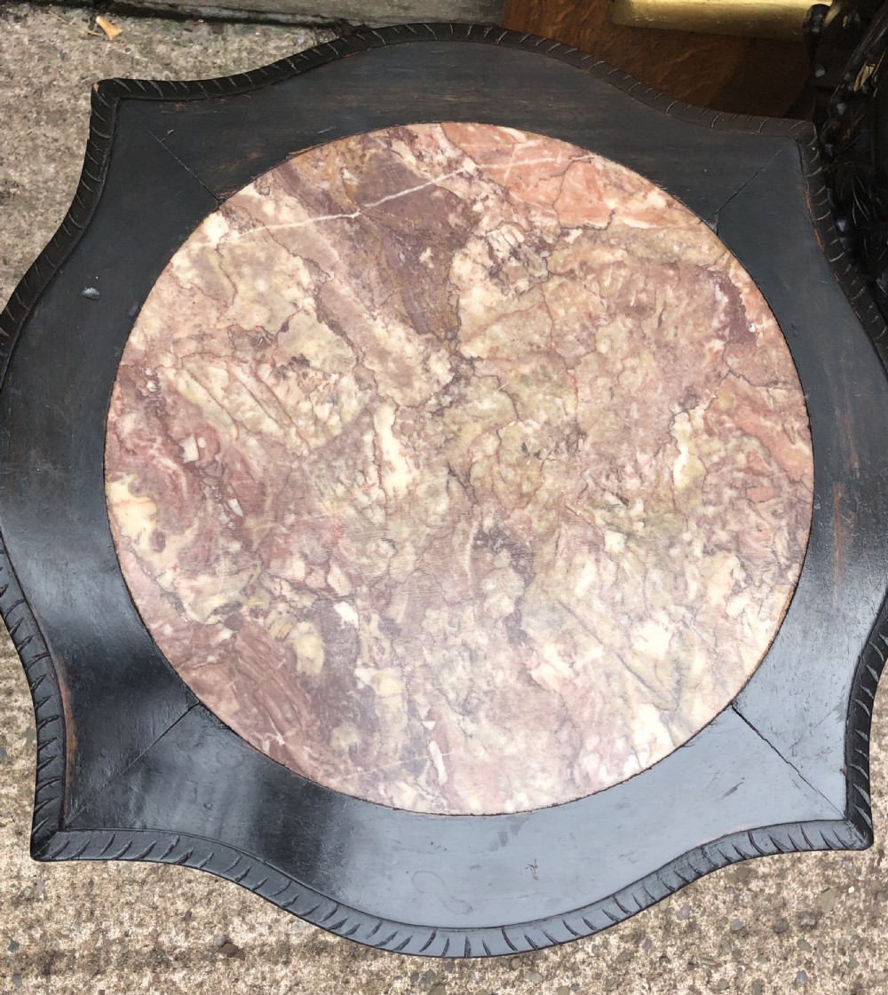 Pair of ebonised wooden side tables featuring pierced floral carvings and circular pink marble inset tops. View VII