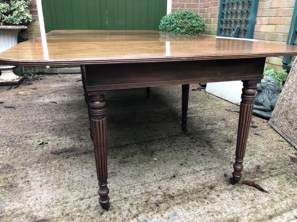 Early C19th late George III period mahogany extending dining table of unusual format . View II