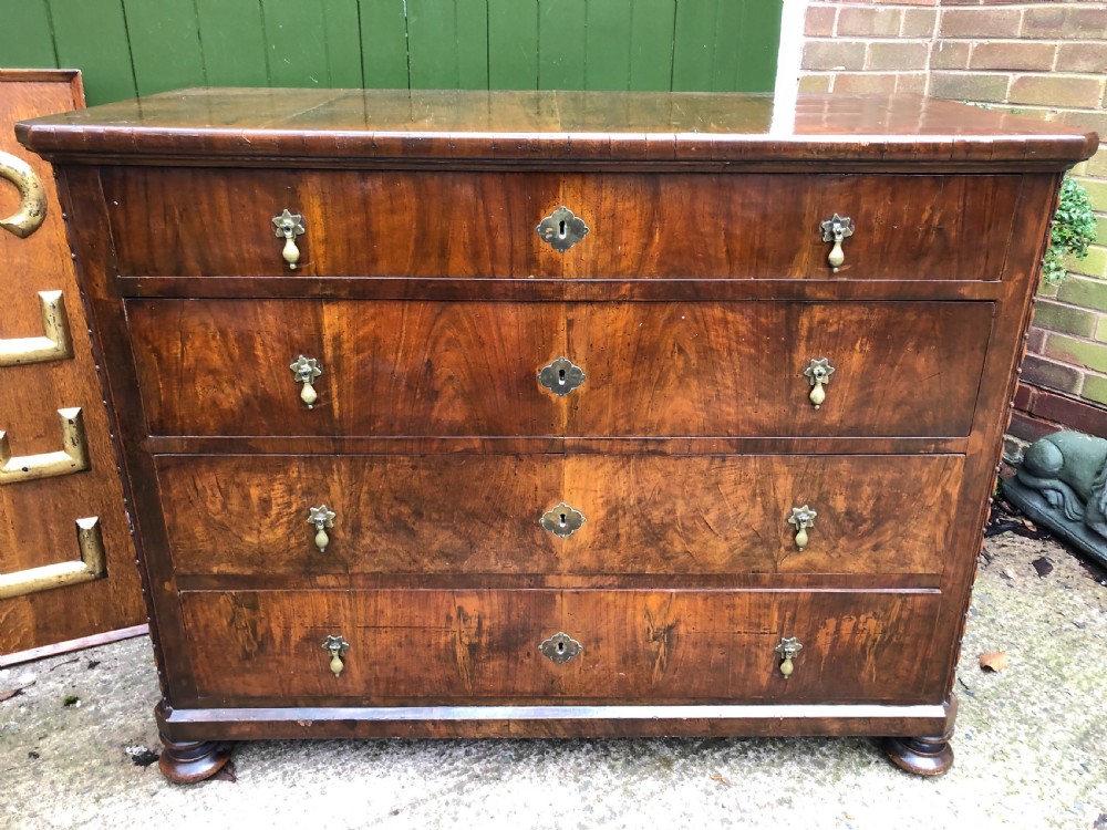 A late eighteenth-century Continental walnut commode chest featuring four long drawers with brass handles and brass escutcheons. View V