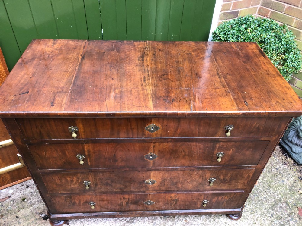 A late eighteenth-century Continental walnut commode chest featuring four long drawers with brass handles and brass escutcheons. View VI