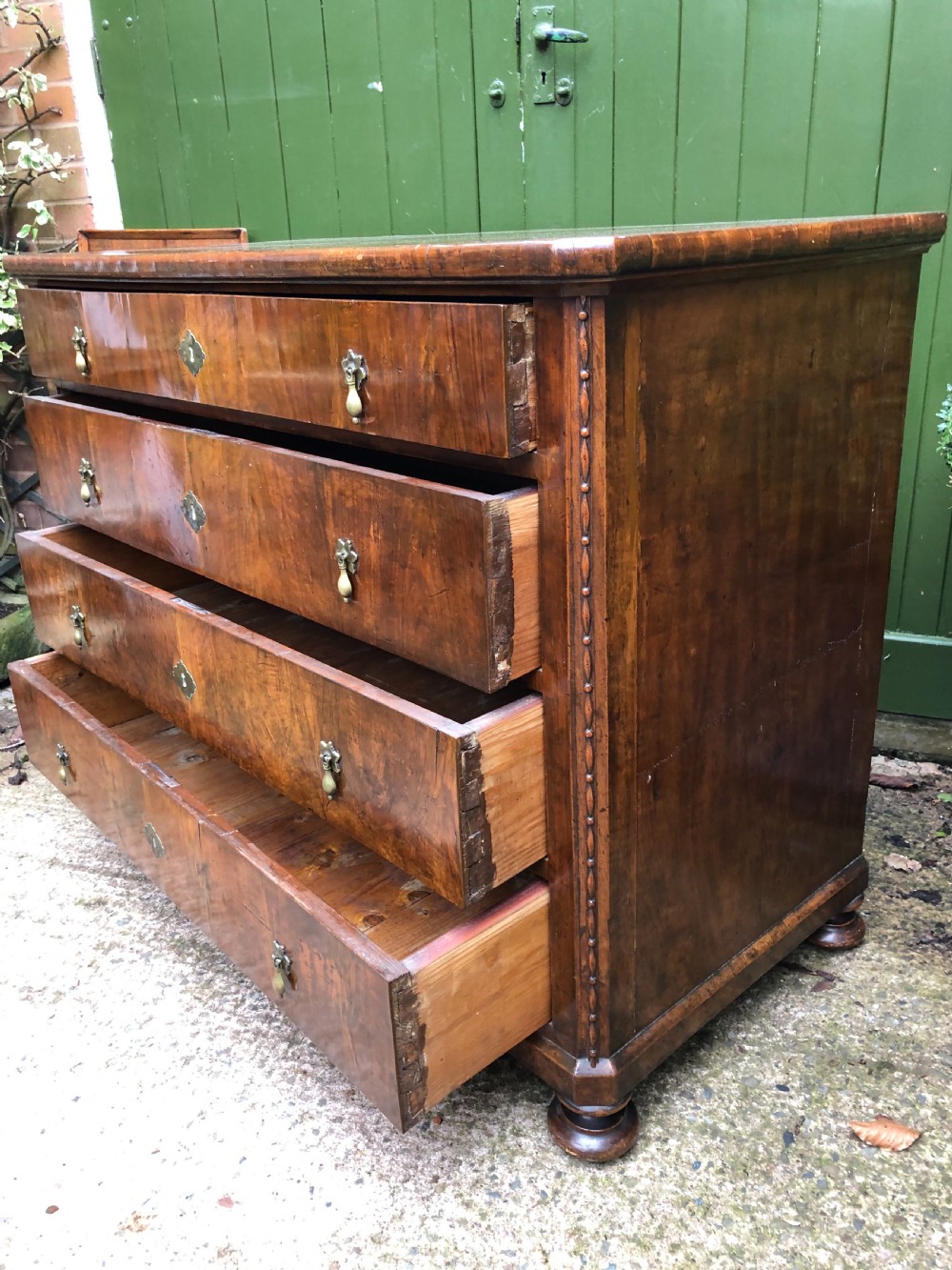 A late eighteenth-century Continental walnut commode chest featuring four long drawers with brass handles and brass escutcheons. View VIII