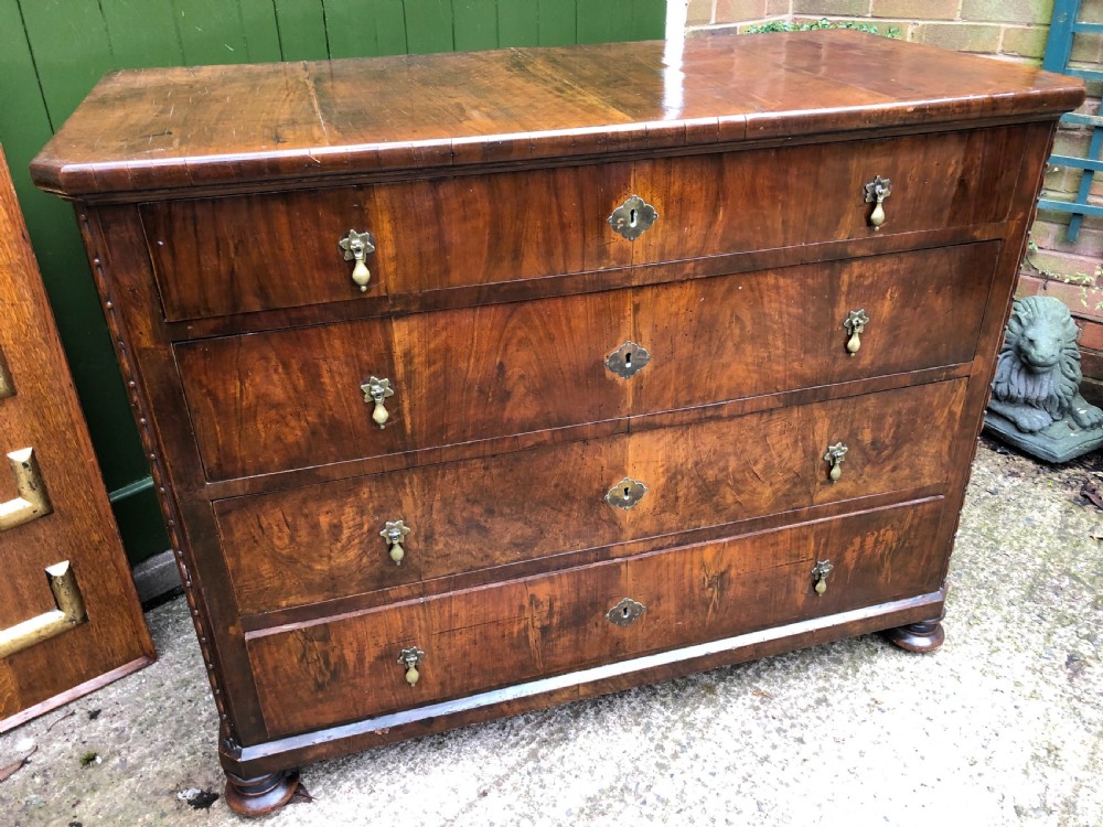 A late eighteenth-century Continental walnut commode chest featuring four long drawers with brass handles and brass escutcheons. View XI
