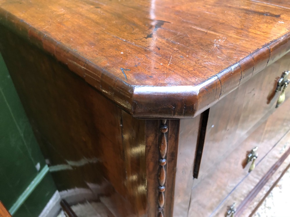 A late eighteenth-century Continental walnut commode chest featuring four long drawers with brass handles and brass escutcheons. View XII