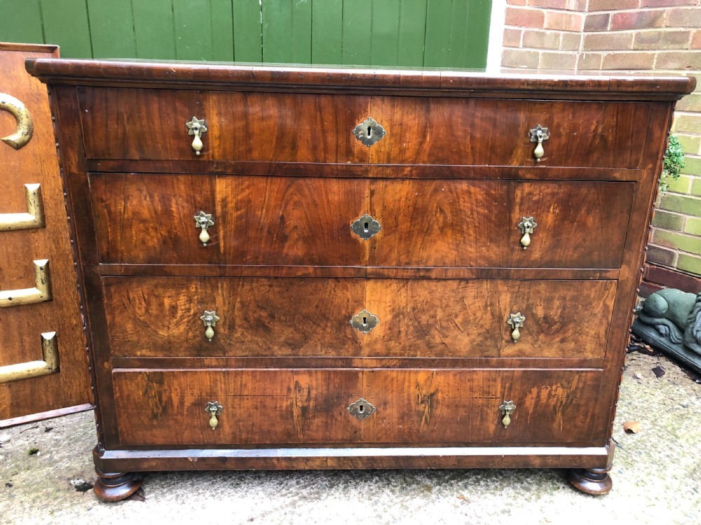 A late eighteenth-century Continental walnut commode chest featuring four long drawers with brass handles and brass escutcheons. View XV
