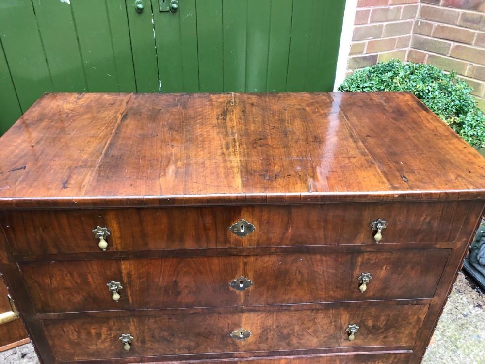 A late eighteenth-century Continental walnut commode chest featuring four long drawers with brass handles and brass escutcheons. View XVI
