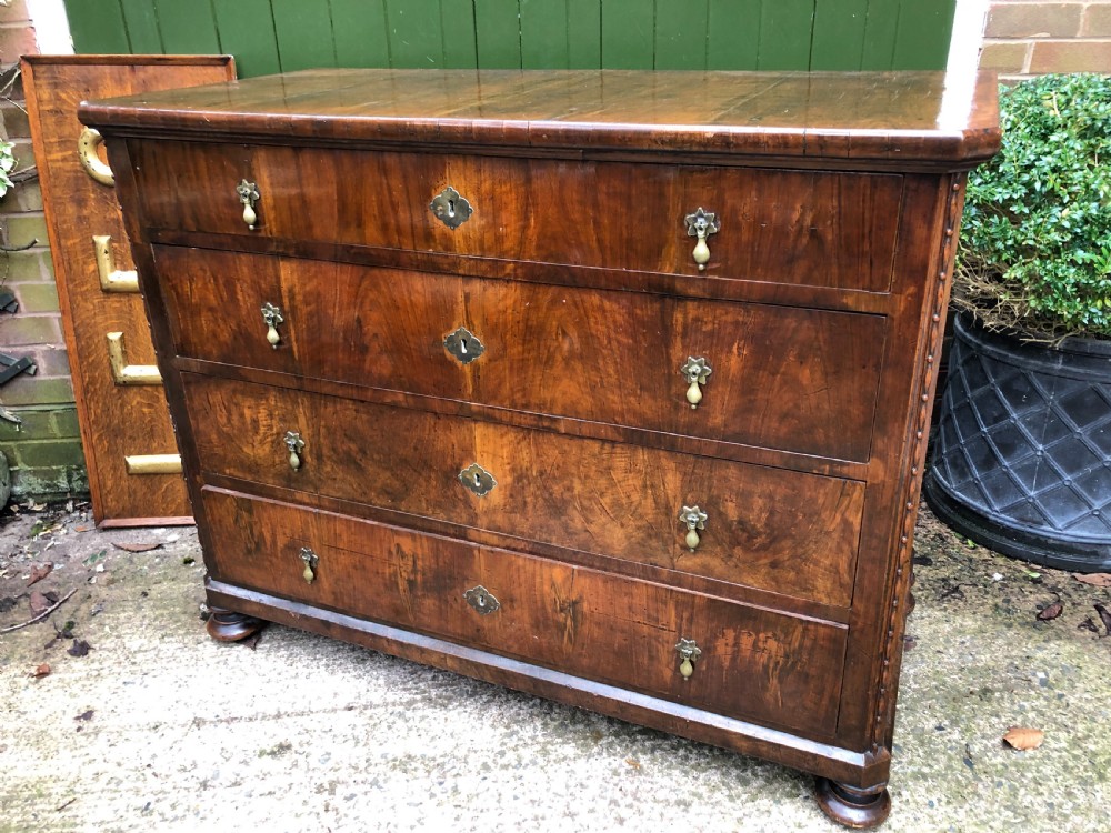 A late eighteenth-century Continental walnut commode chest featuring four long drawers with brass handles and brass escutcheons. View XIX