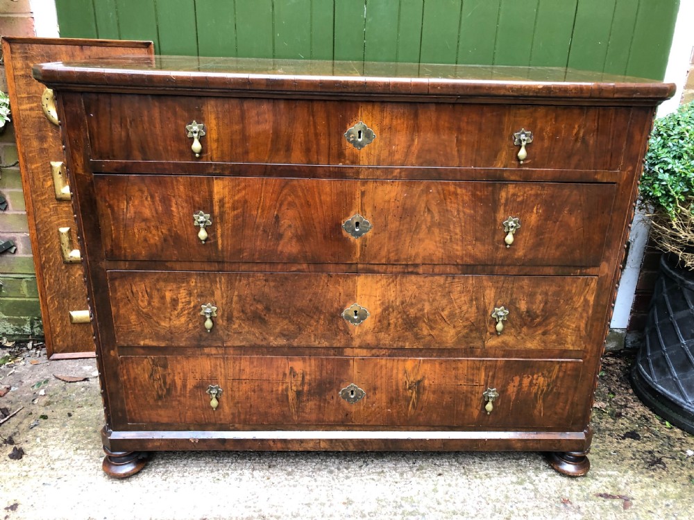 A late eighteenth-century Continental walnut commode chest featuring four long drawers with brass handles and brass escutcheons. View XX