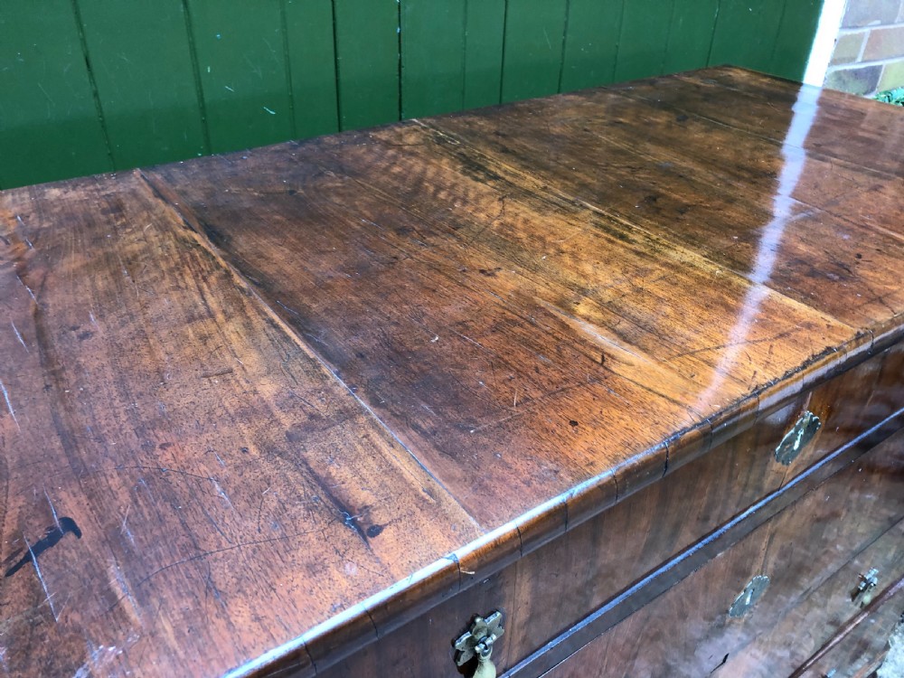 A late eighteenth-century Continental walnut commode chest featuring four long drawers with brass handles and brass escutcheons. View XXII