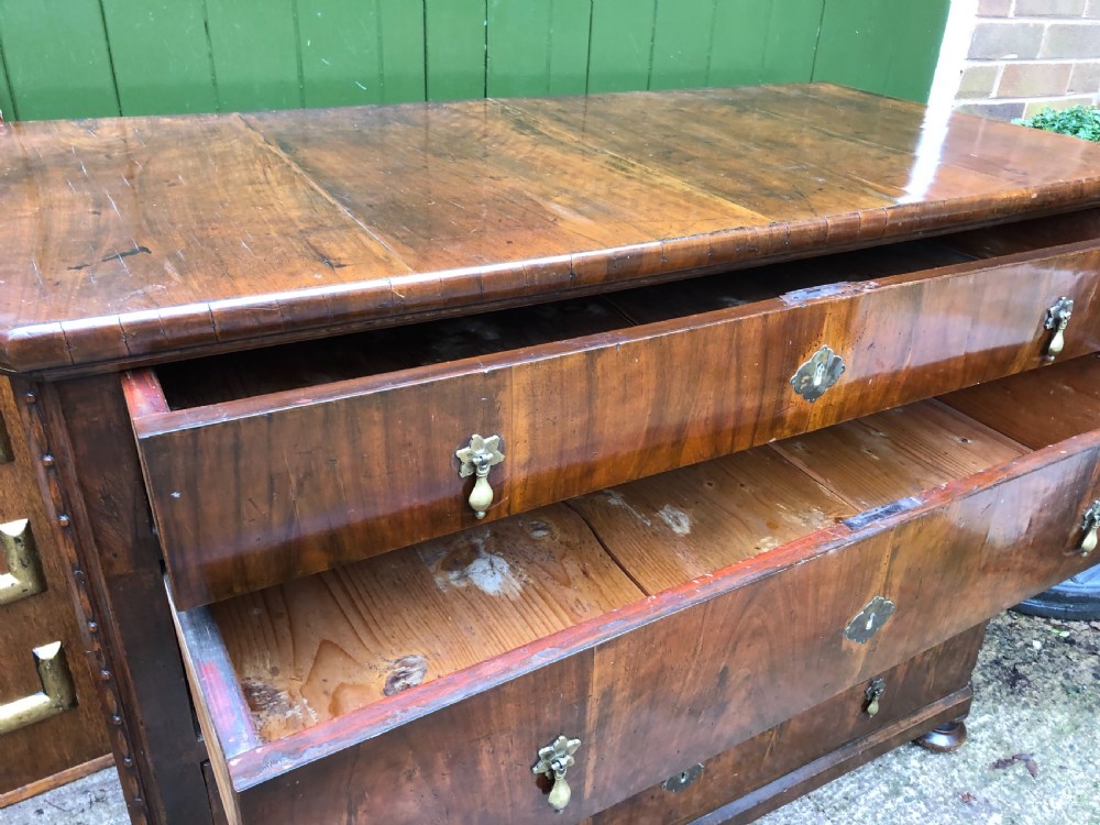 A late eighteenth-century Continental walnut commode chest featuring four long drawers with brass handles and brass escutcheons. View XXIV