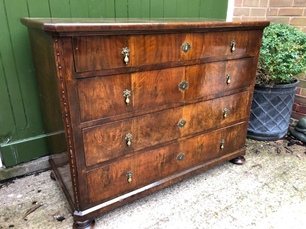 A late eighteenth-century Continental walnut commode chest featuring four long drawers with brass handles and brass escutcheons. View XXVI