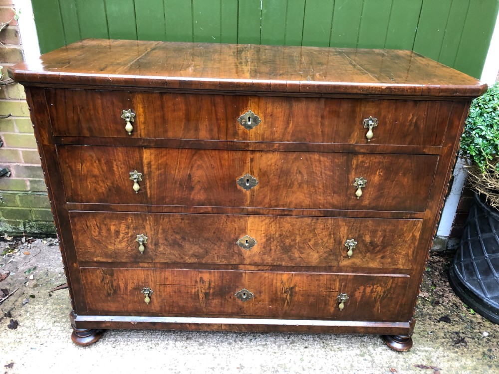 A late eighteenth-century Continental walnut commode chest featuring four long drawers with brass handles and brass escutcheons. View XXVII