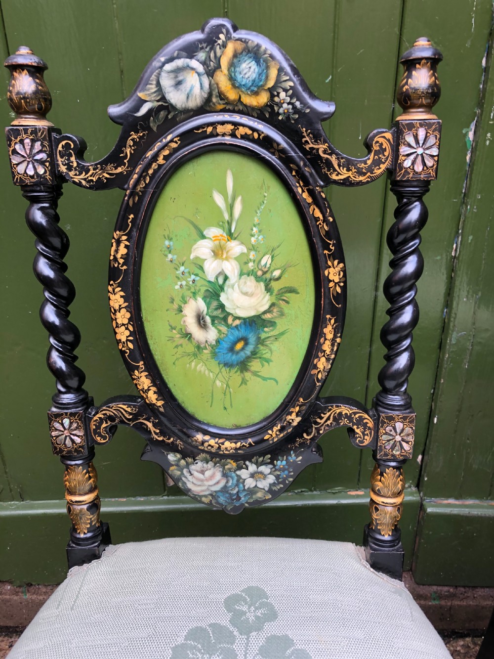 A pair of black lacquered Victorian bedroom chairs featuring oval back panels painted with floral motifs, mother-of-pearl inlay, barley twist legs, and light green upholstered seats. View II