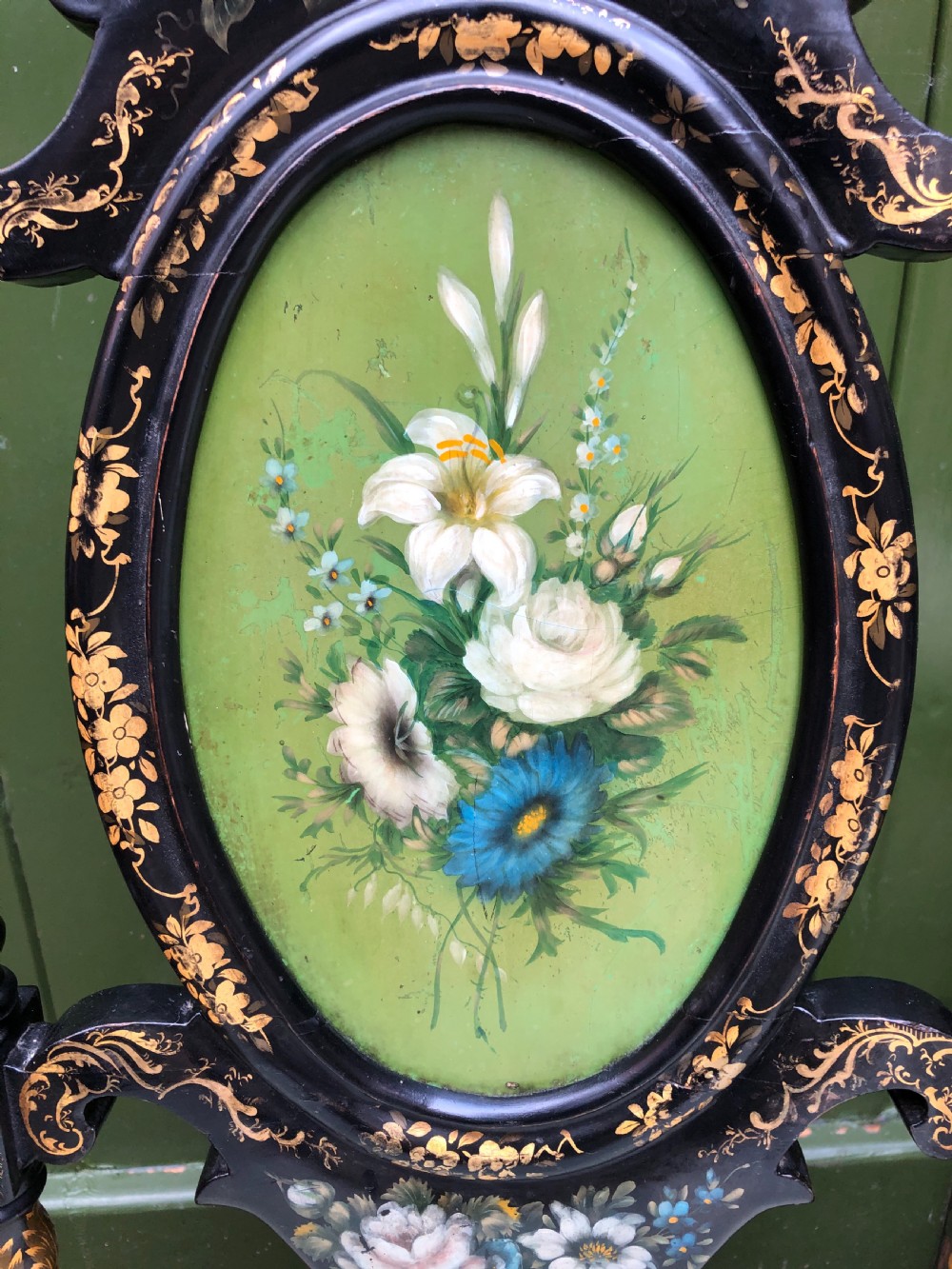 A pair of black lacquered Victorian bedroom chairs featuring oval back panels painted with floral motifs, mother-of-pearl inlay, barley twist legs, and light green upholstered seats. View III