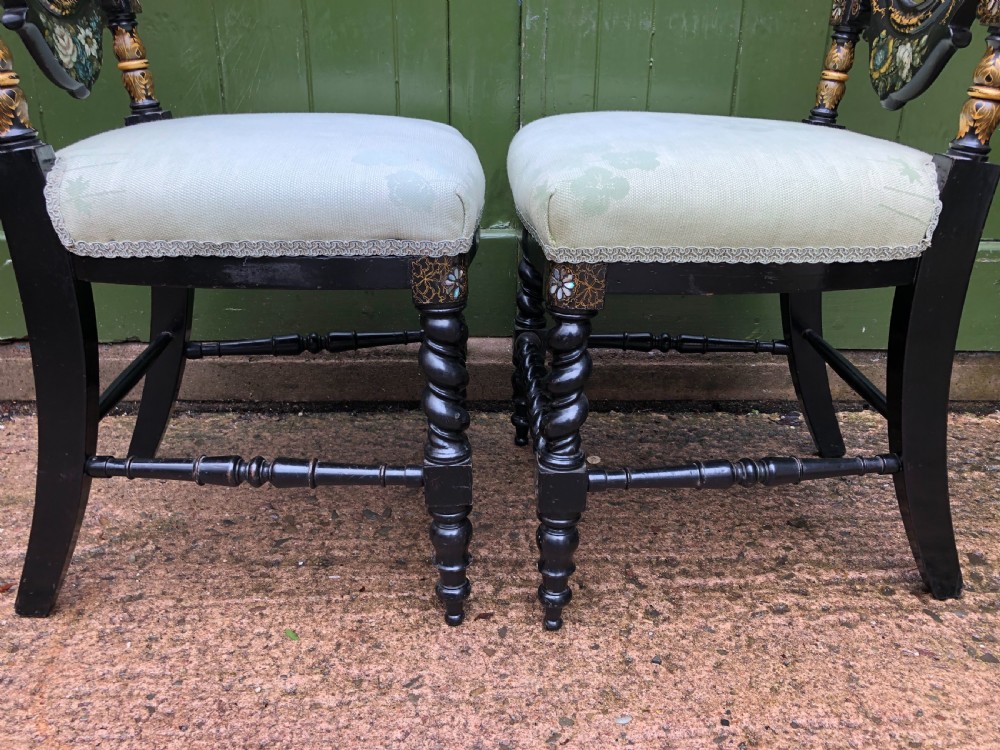 A pair of black lacquered Victorian bedroom chairs featuring oval back panels painted with floral motifs, mother-of-pearl inlay, barley twist legs, and light green upholstered seats. View VII