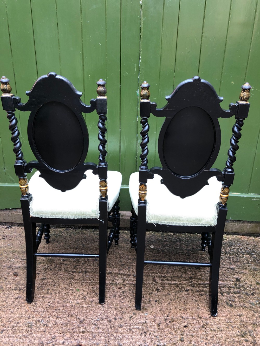 A pair of black lacquered Victorian bedroom chairs featuring oval back panels painted with floral motifs, mother-of-pearl inlay, barley twist legs, and light green upholstered seats. View VIII