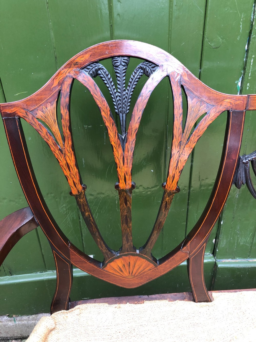 A late nineteenth-century mahogany double chair-back settee featuring shield-shaped backs with satinwood plume inlay and tapered legs. View III