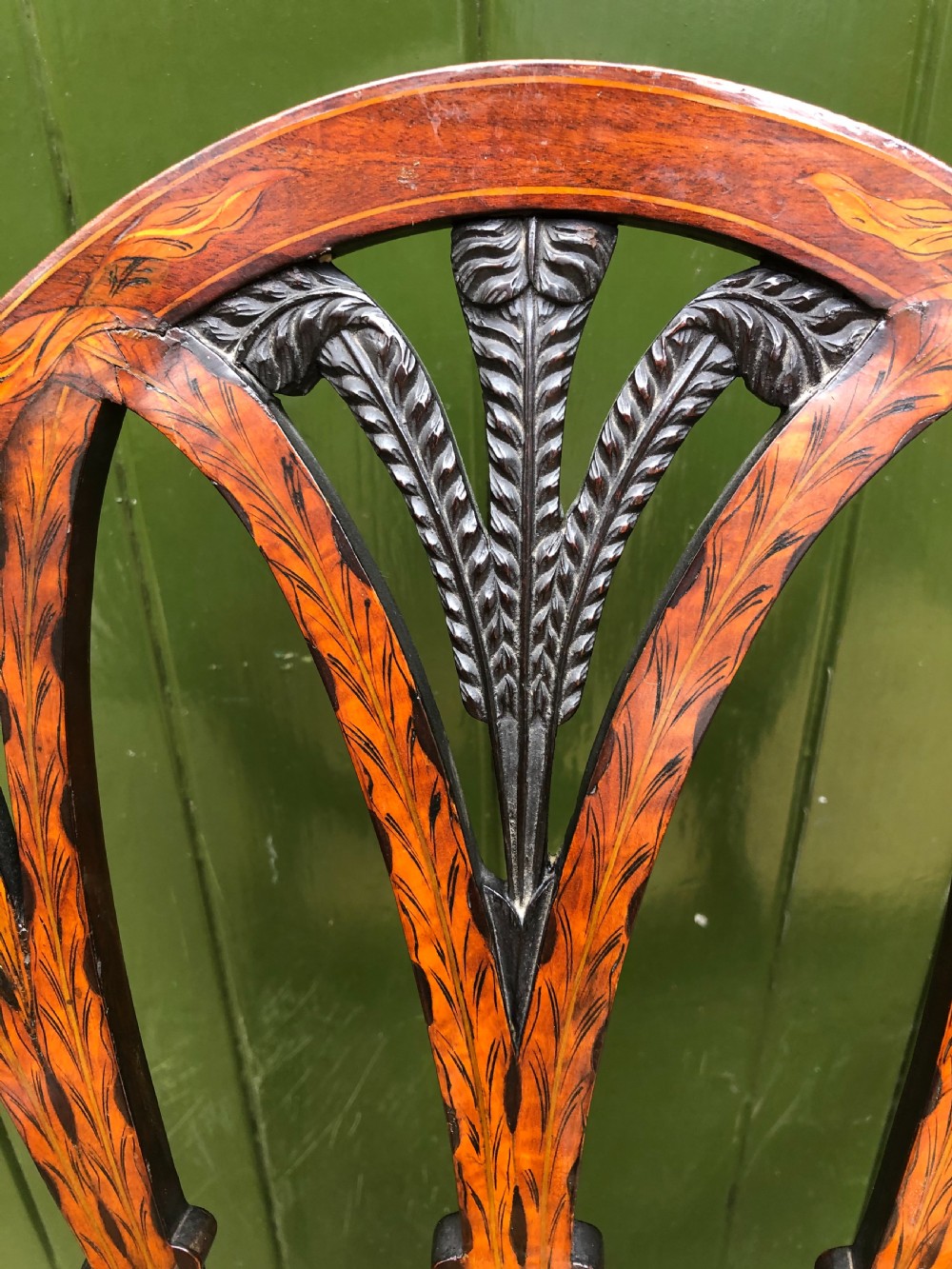 A late nineteenth-century mahogany double chair-back settee featuring shield-shaped backs with satinwood plume inlay and tapered legs. View V