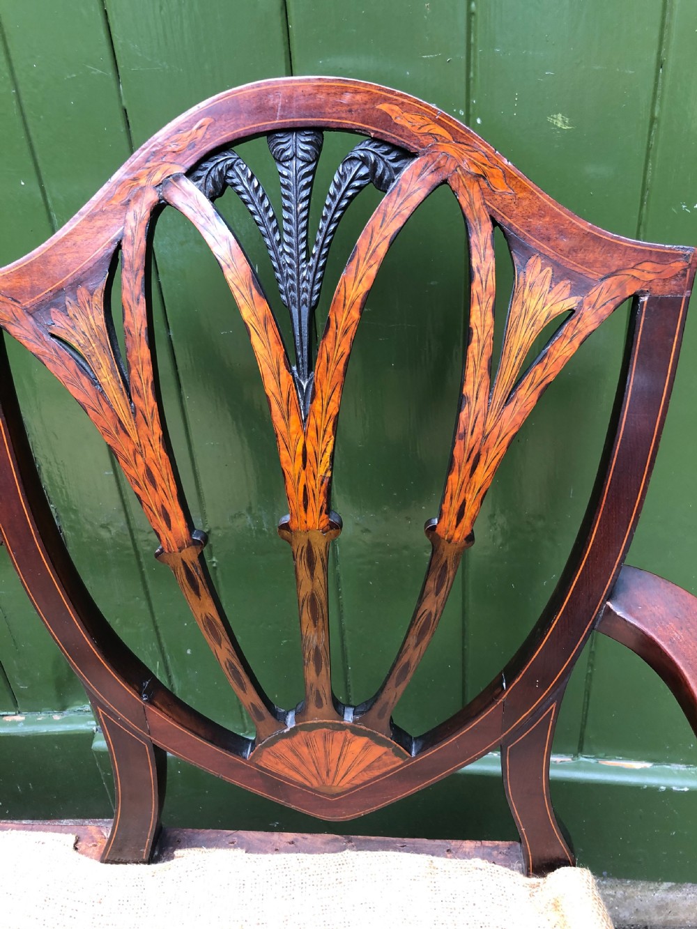 A late nineteenth-century mahogany double chair-back settee featuring shield-shaped backs with satinwood plume inlay and tapered legs. View VIII