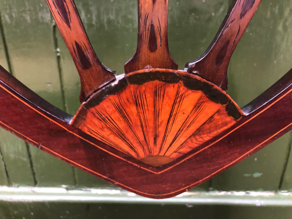 A late nineteenth-century mahogany double chair-back settee featuring shield-shaped backs with satinwood plume inlay and tapered legs. View IX