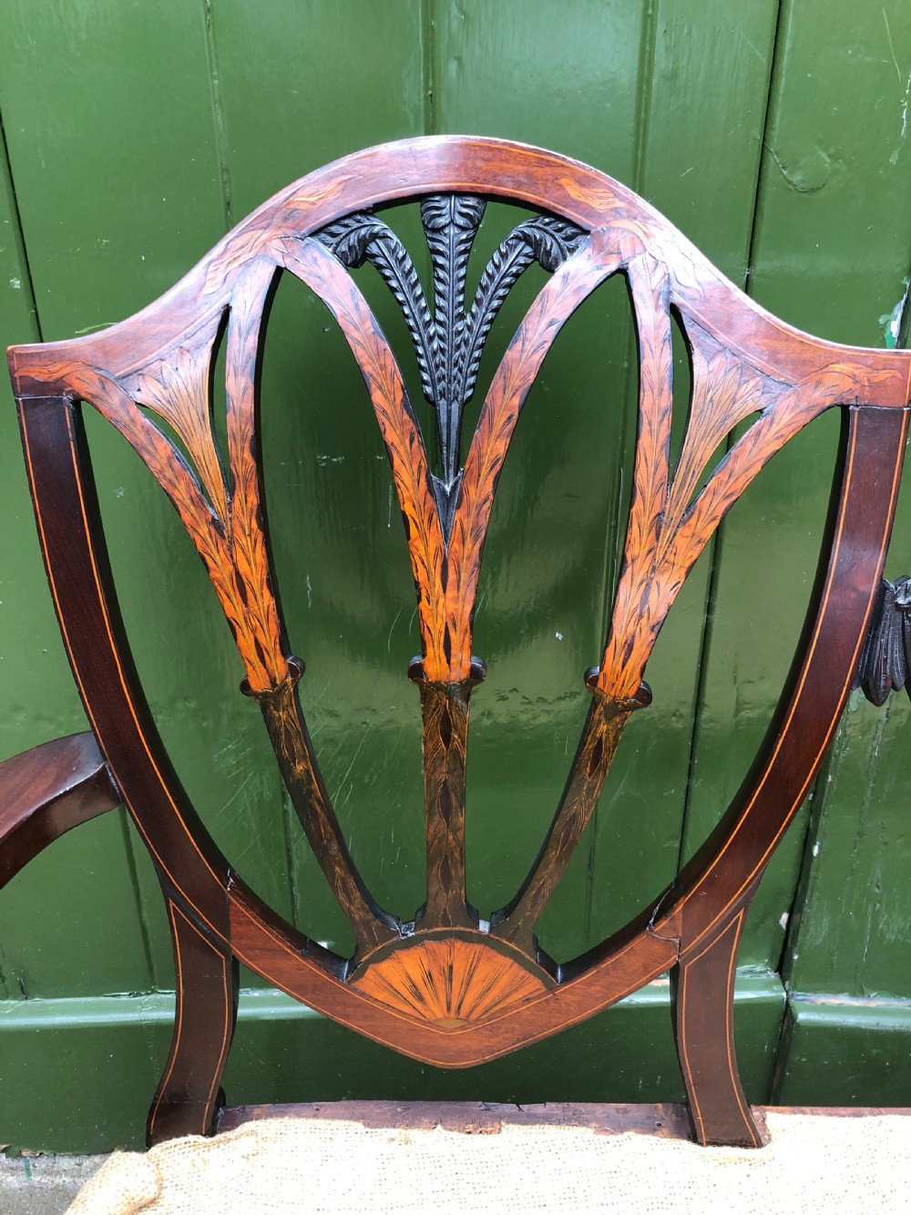 A late nineteenth-century mahogany double chair-back settee featuring shield-shaped backs with satinwood plume inlay and tapered legs. View X