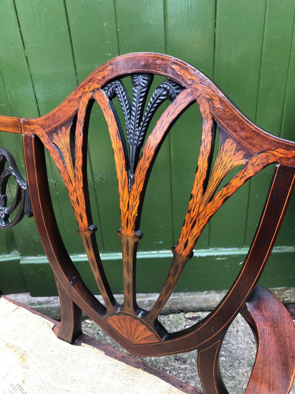 A late nineteenth-century mahogany double chair-back settee featuring shield-shaped backs with satinwood plume inlay and tapered legs. View XIV