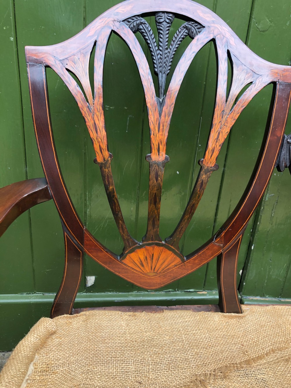 A late nineteenth-century mahogany double chair-back settee featuring shield-shaped backs with satinwood plume inlay and tapered legs. View XXI