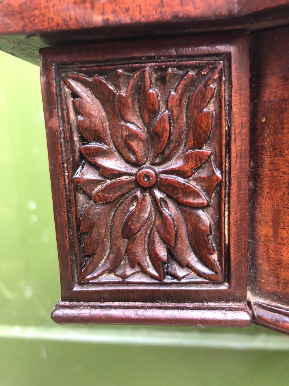 An early 19th-century Regency mahogany fold-over card table featuring carved floral frieze panels, a bulbous carved pedestal stem, and four splayed legs with brass castors. View XIV