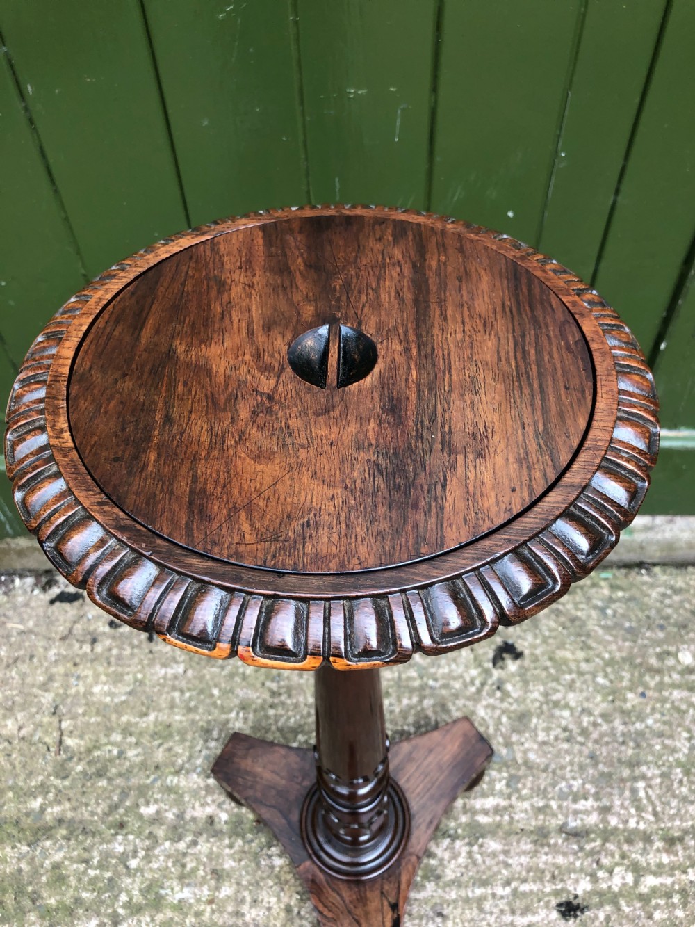 An early 19th-century carved rosewood jardiniere stand featuring a gadrooned top rim, turned column shaft, and a triform base. View V