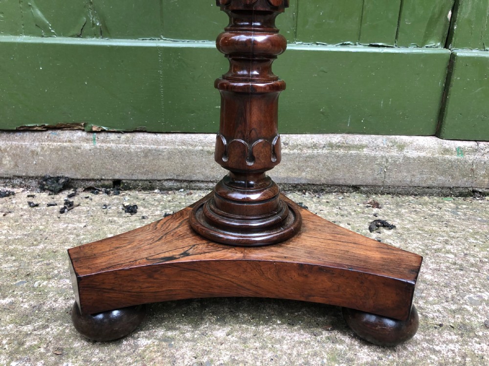 An early 19th-century carved rosewood jardiniere stand featuring a gadrooned top rim, turned column shaft, and a triform base. View VIII