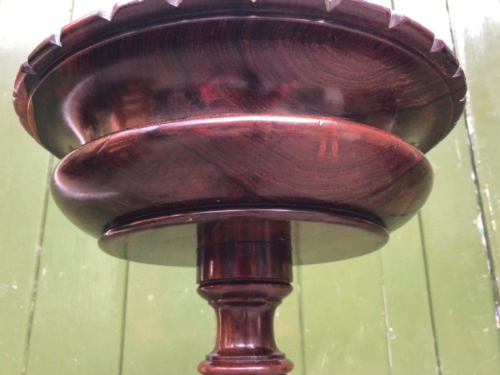 An early 19th-century carved rosewood jardiniere stand featuring a gadrooned top rim, turned column shaft, and a triform base. View IX