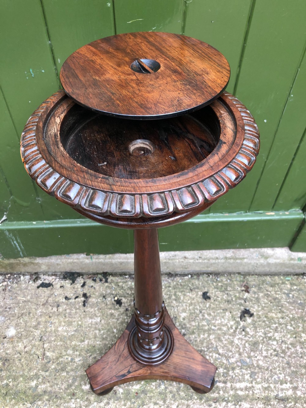 An early 19th-century carved rosewood jardiniere stand featuring a gadrooned top rim, turned column shaft, and a triform base. View XI