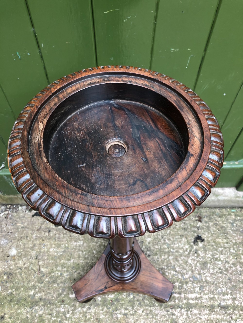 An early 19th-century carved rosewood jardiniere stand featuring a gadrooned top rim, turned column shaft, and a triform base. View XII