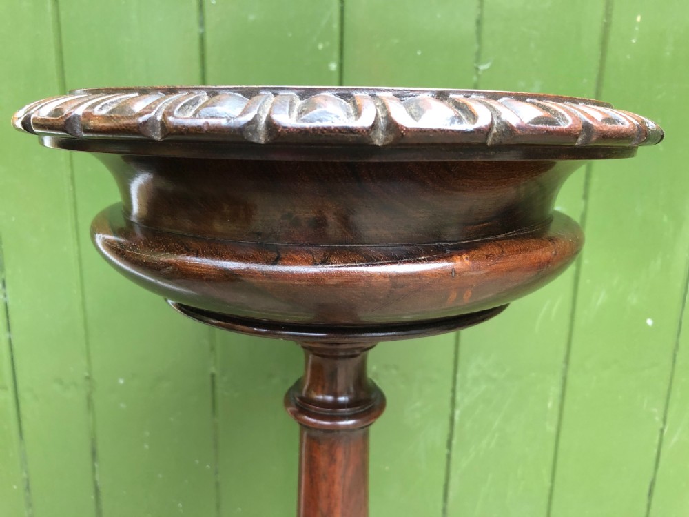 An early 19th-century carved rosewood jardiniere stand featuring a gadrooned top rim, turned column shaft, and a triform base. View XIII