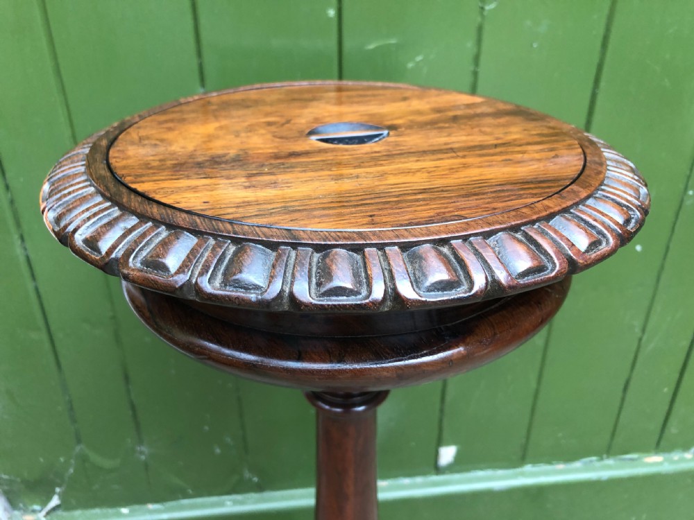 An early 19th-century carved rosewood jardiniere stand featuring a gadrooned top rim, turned column shaft, and a triform base. View XIV