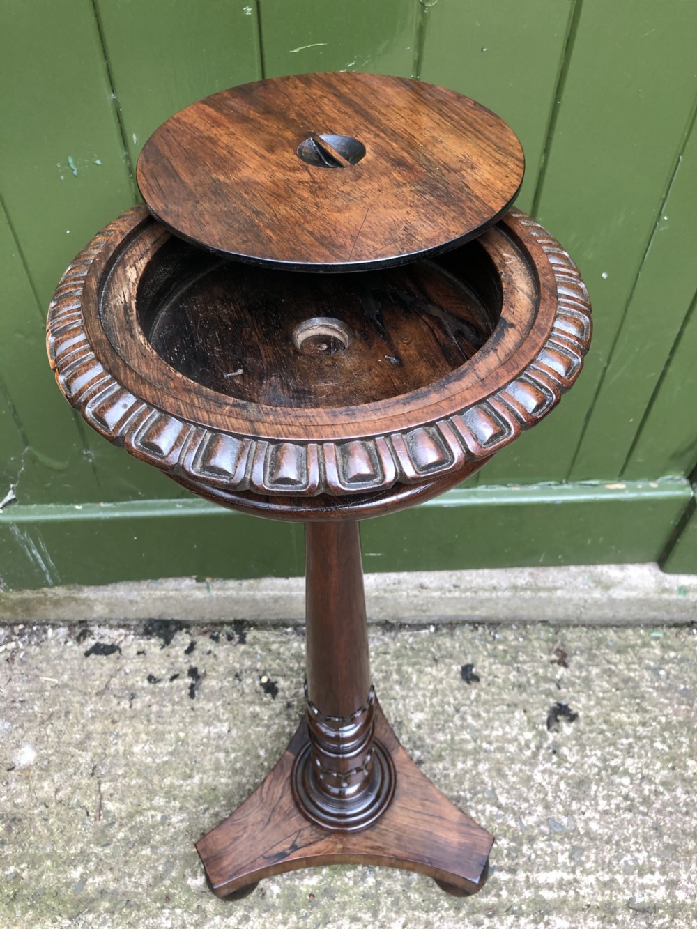 An early 19th-century carved rosewood jardiniere stand featuring a gadrooned top rim, turned column shaft, and a triform base. View VI