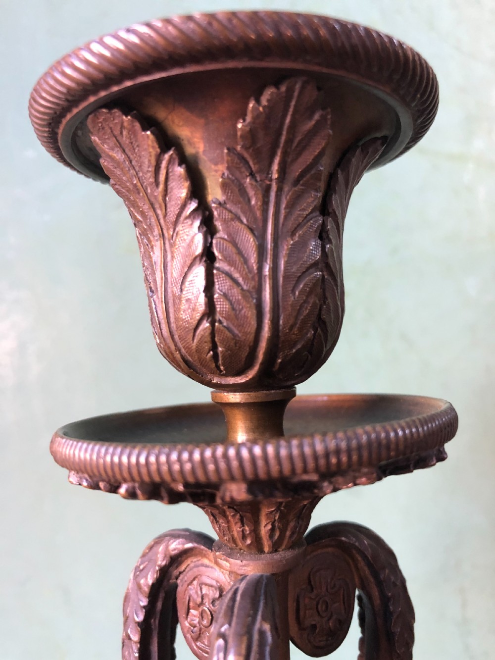 A pair of early nineteenth-century Regency bronze candlesticks designed in classical Athenienne tripod form with leaf sconces and plinth bases. View IV