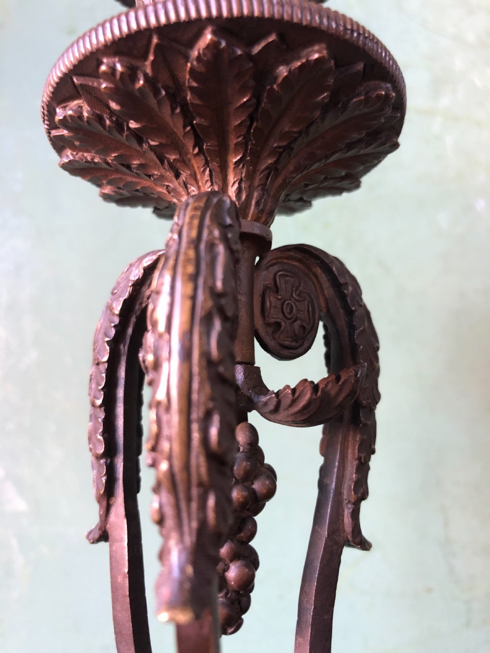A pair of early nineteenth-century Regency bronze candlesticks designed in classical Athenienne tripod form with leaf sconces and plinth bases. View V