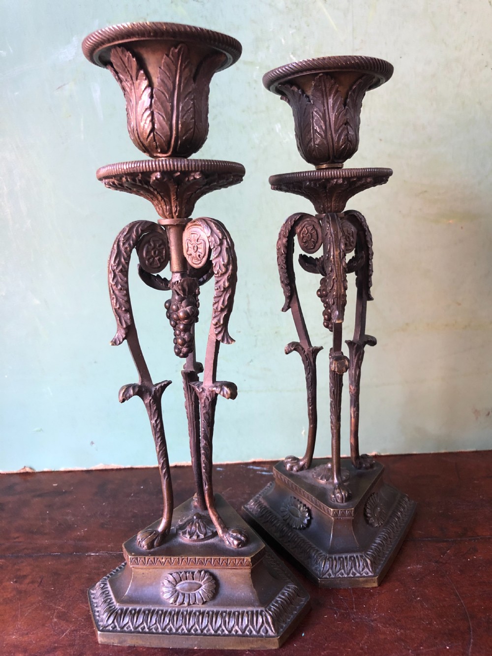 A pair of early nineteenth-century Regency bronze candlesticks designed in classical Athenienne tripod form with leaf sconces and plinth bases. View VII