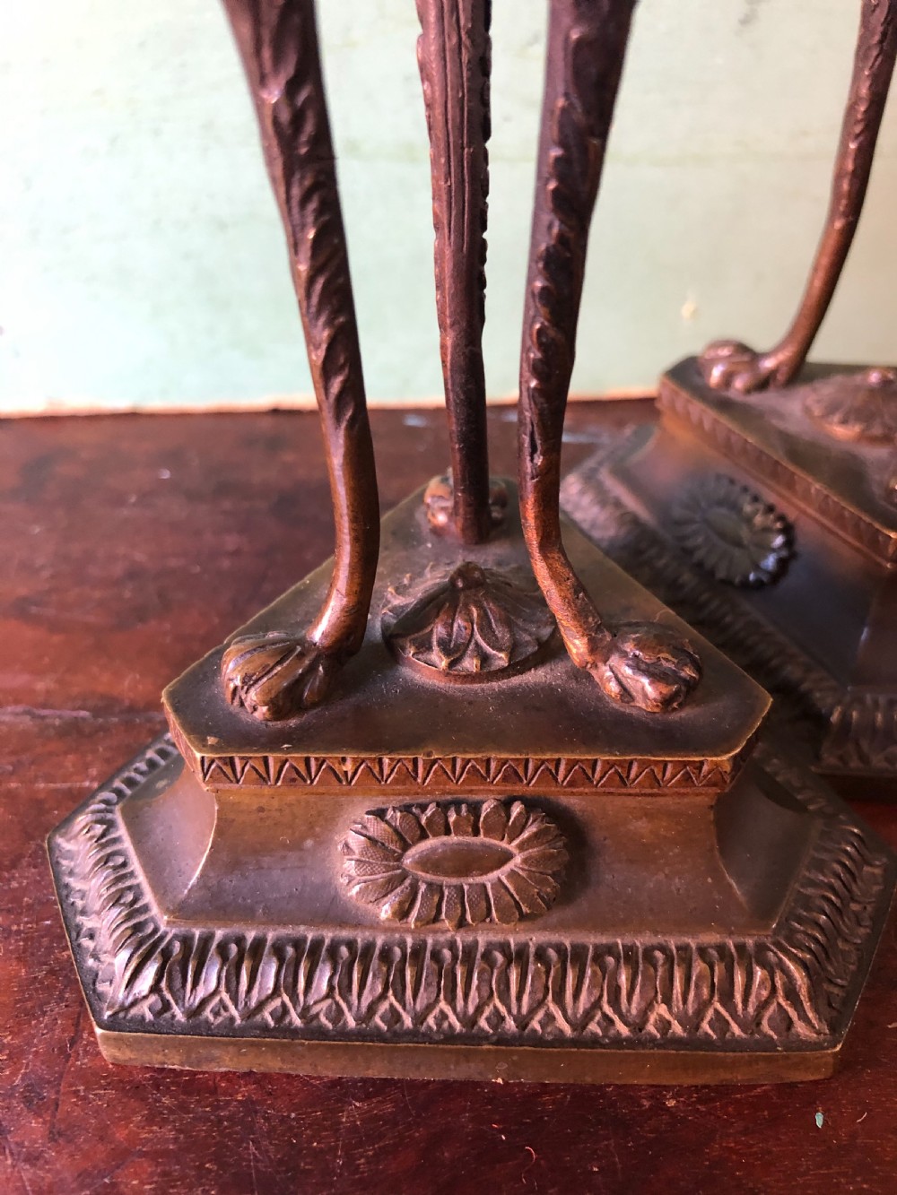 A pair of early nineteenth-century Regency bronze candlesticks designed in classical Athenienne tripod form with leaf sconces and plinth bases. View IX
