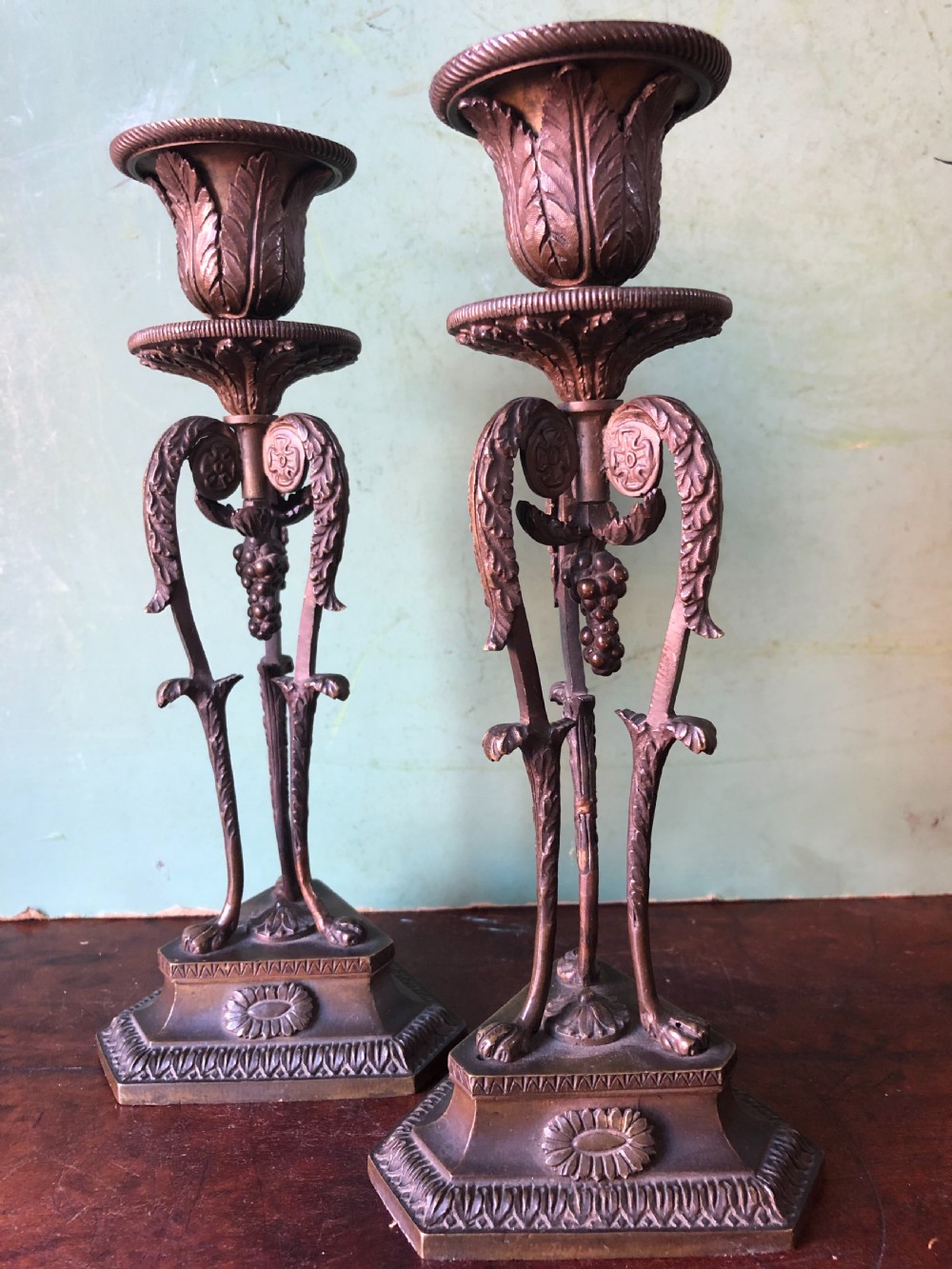A pair of early nineteenth-century Regency bronze candlesticks designed in classical Athenienne tripod form with leaf sconces and plinth bases. View XI