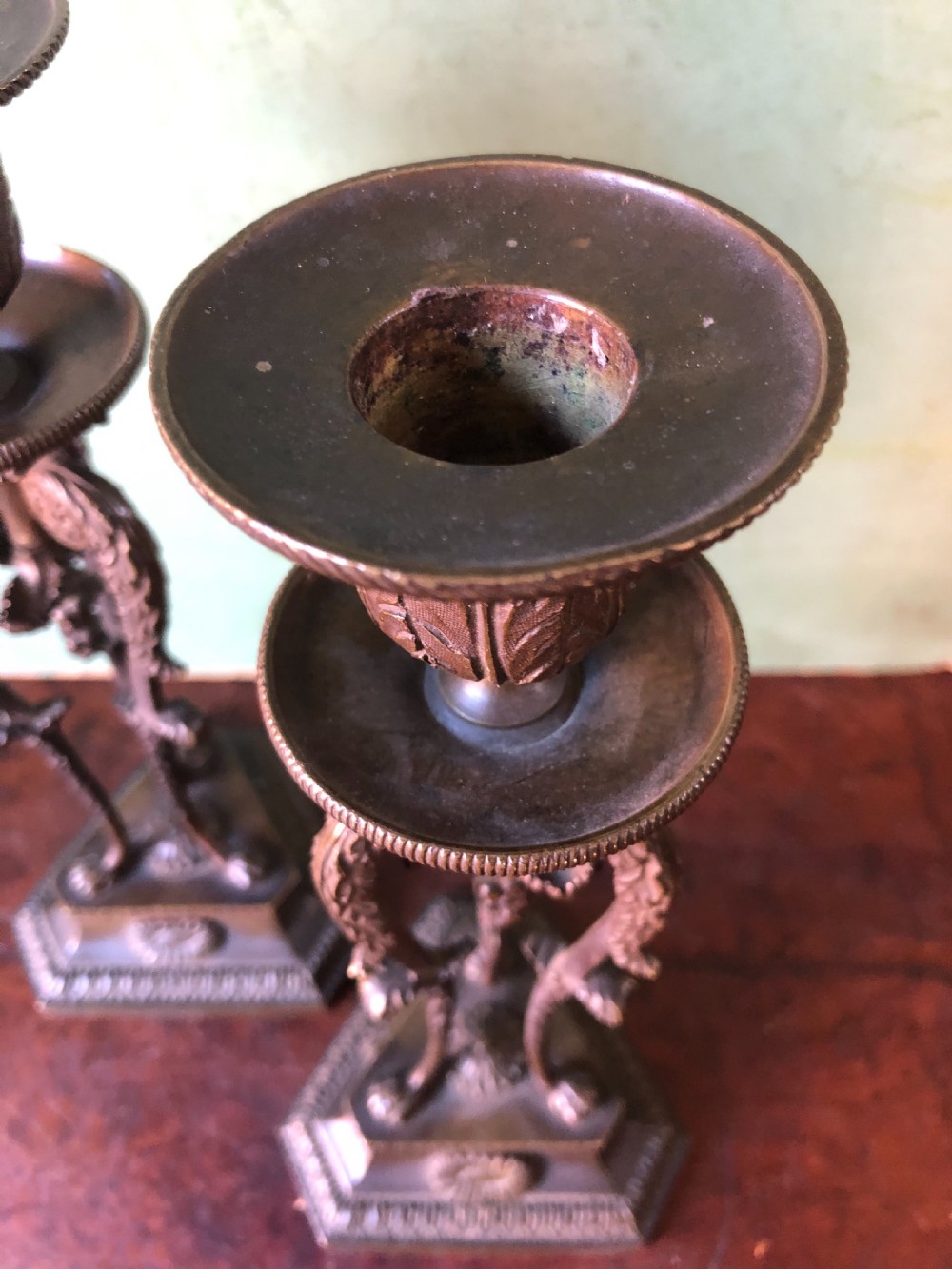 A pair of early nineteenth-century Regency bronze candlesticks designed in classical Athenienne tripod form with leaf sconces and plinth bases. View XII