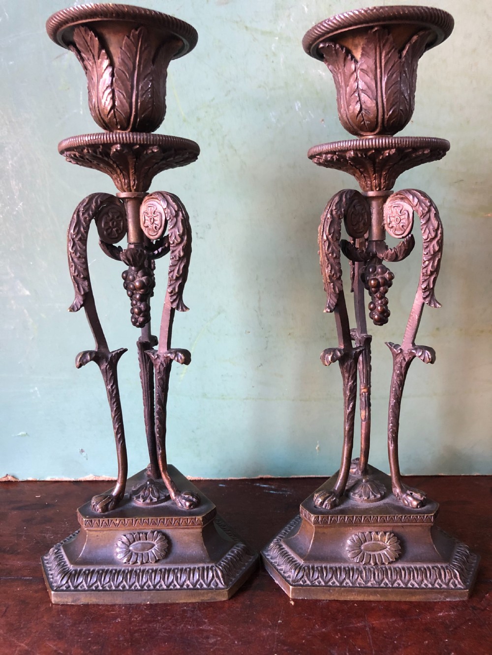 A pair of early nineteenth-century Regency bronze candlesticks designed in classical Athenienne tripod form with leaf sconces and plinth bases. View XV