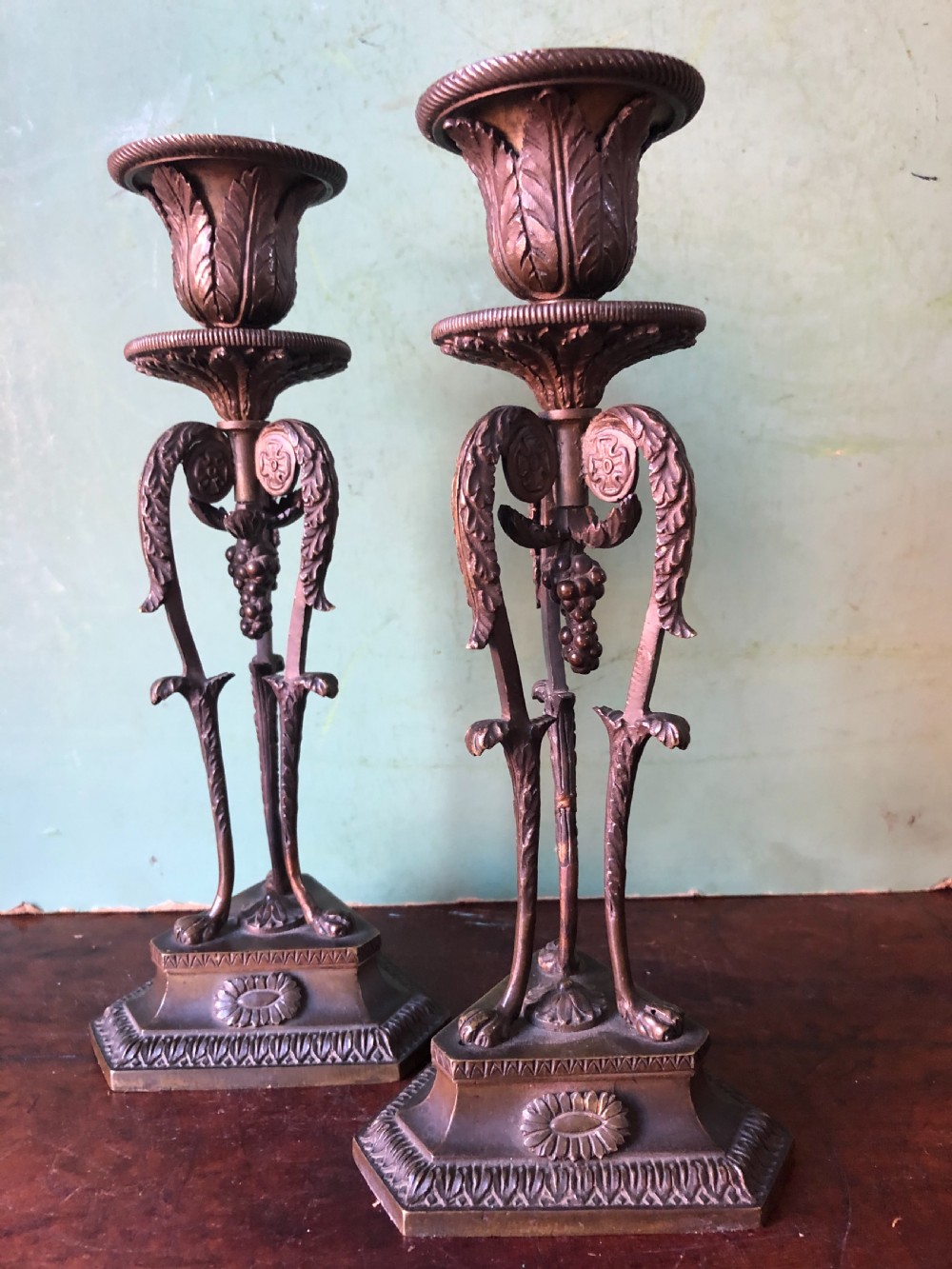 A pair of early nineteenth-century Regency bronze candlesticks designed in classical Athenienne tripod form with leaf sconces and plinth bases. View XVI