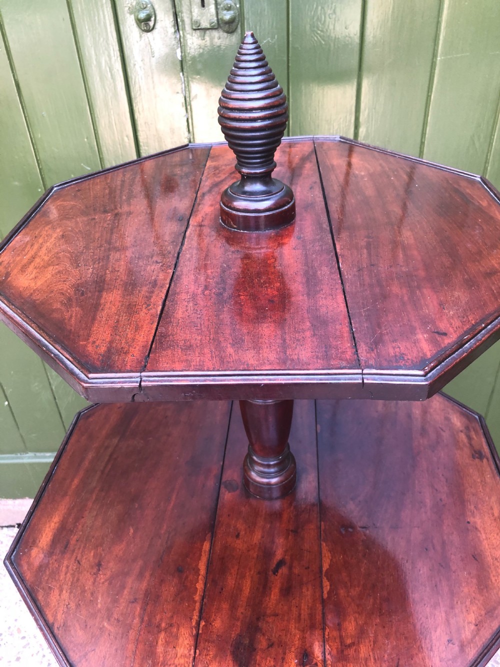 A late eighteenth-century George III mahogany two-tier dumb waiter table featuring octagonal drop-leaf surfaces supported by a turned central column on tripod legs with brass castors. View VI
