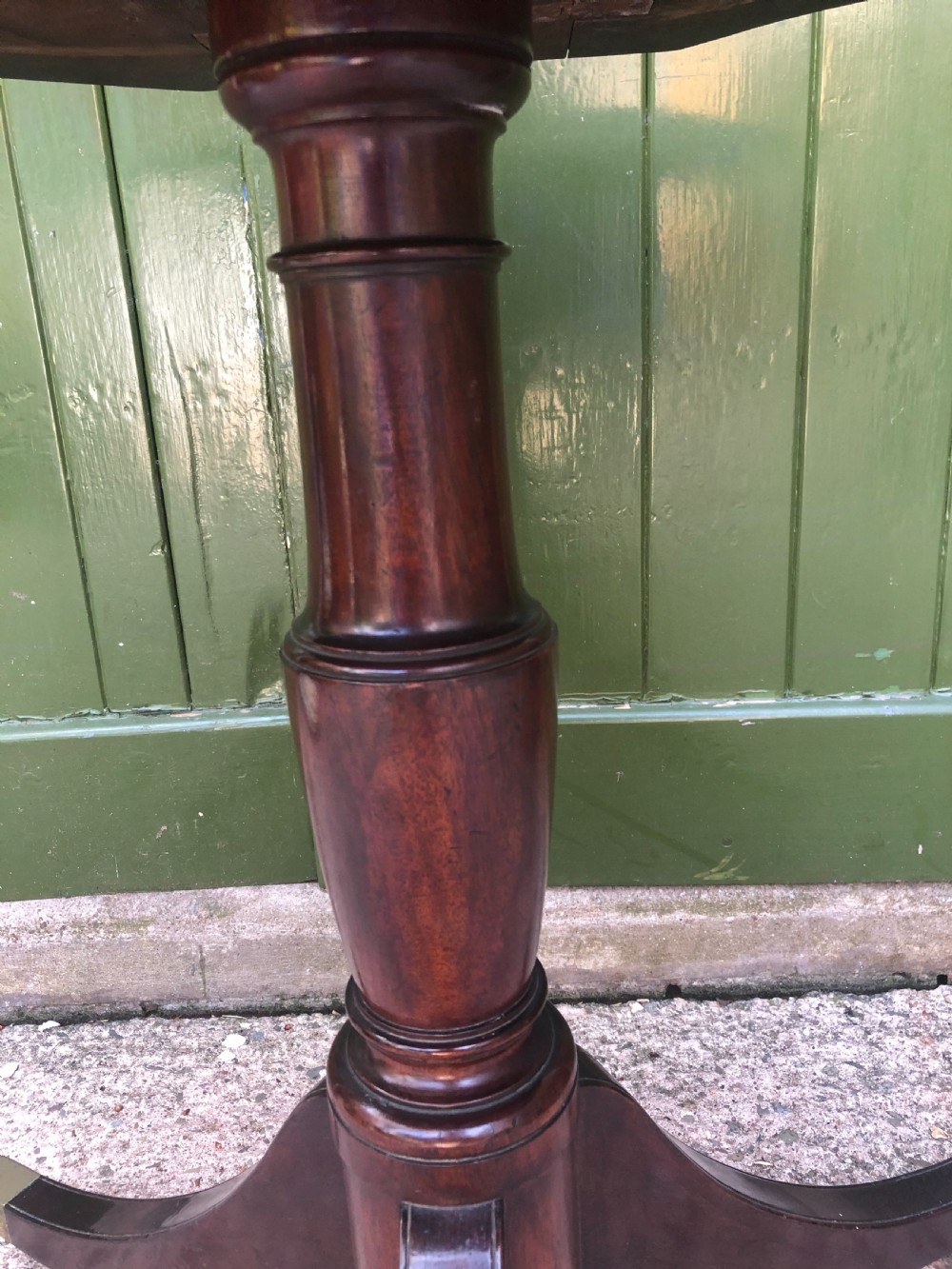 A late eighteenth-century George III mahogany two-tier dumb waiter table featuring octagonal drop-leaf surfaces supported by a turned central column on tripod legs with brass castors. View VIII
